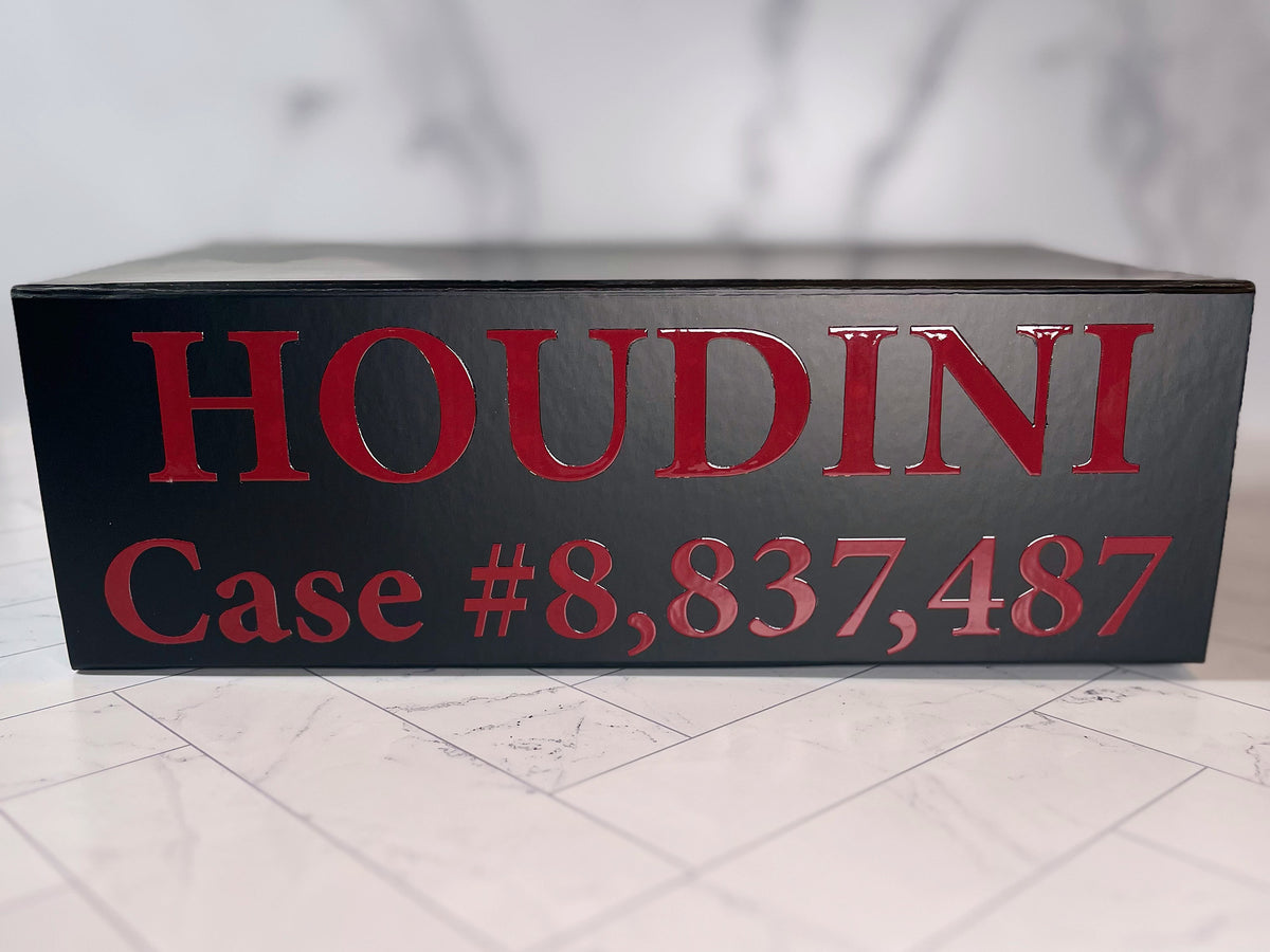 A sleek black box labeled “The Murder Box Edition” in bold red lettering stands out against a marble background—this eye-catching presentation is part of the exclusive Houdini collector’s edition and features a signed limited edition book to honor the 100th Anniversary of Houdini’s death.